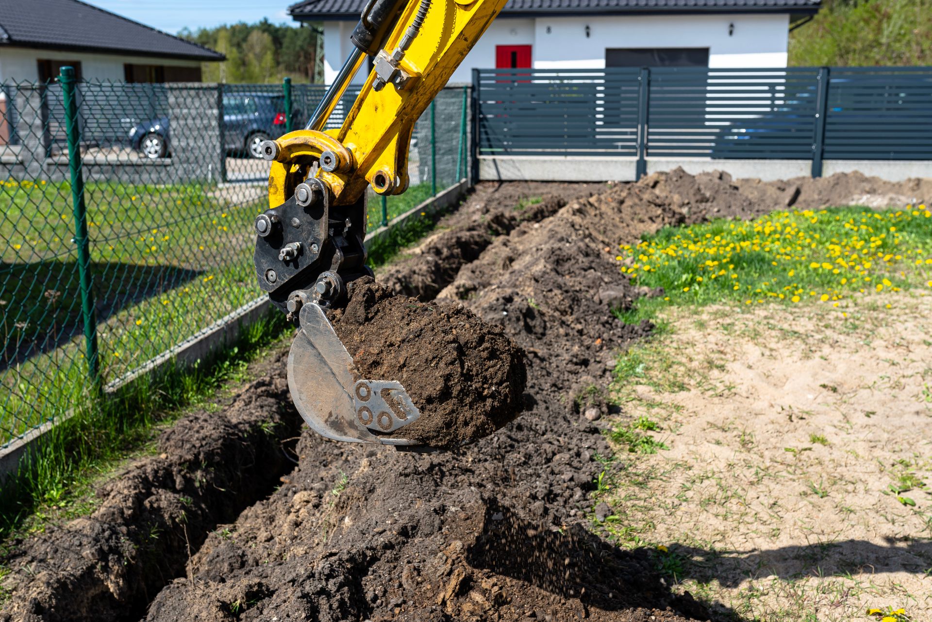 Kran hebt vorgefertigtes Wandelement auf Baustelle.