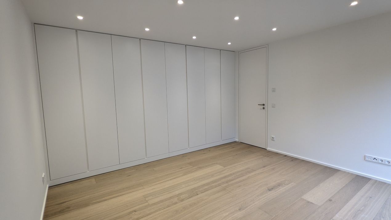 Weißer Einbauschrank mit klaren Linien in minimalistischem Schlafzimmer – Möbelbau Berlin auf Maß umgesetzt